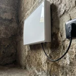 Aparelhos de tratamento de humidade instalados em parede de pedra deteriorada